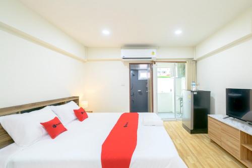 Bang SuHoenhao Boutique Ratchada的一间卧室配有一张带红色枕头的床和电视。