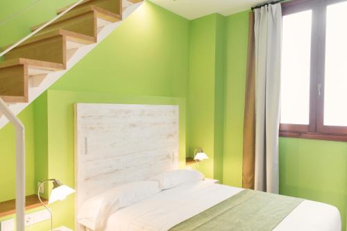 瓦伦西亚阿德霍克卡门酒店的一间卧室设有绿色的墙壁和楼梯