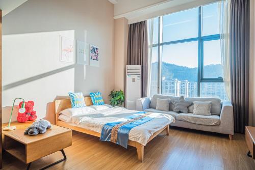 杭州柒月酒店（杭州宋城美院店）的一间卧室配有一张床和一张沙发