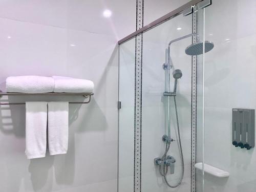 乌隆他尼Banbua Grand Udon的带淋浴和白色毛巾的浴室