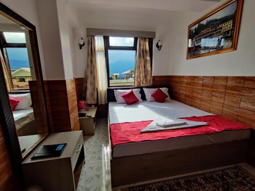 甘托克Matina Regency的一间小卧室,配有一张带红色毯子的床
