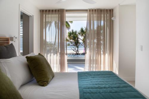 努萨角Netanya Noosa - Beachfront Resort的一间卧室设有一张床,享有海景