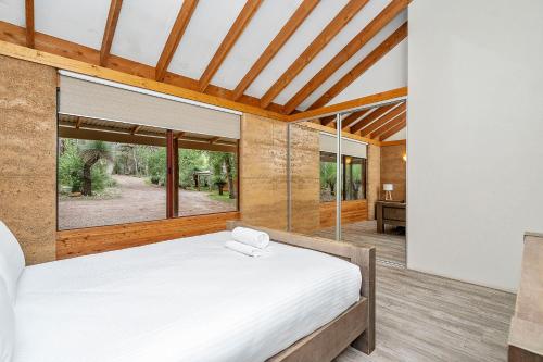 邓斯伯勒Possum Cottage - Woodstone Estate的一间卧室设有一张床和一个大窗户