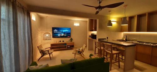 拉巴斯MANGLITO MANILA的带沙发的客厅和带电视的厨房
