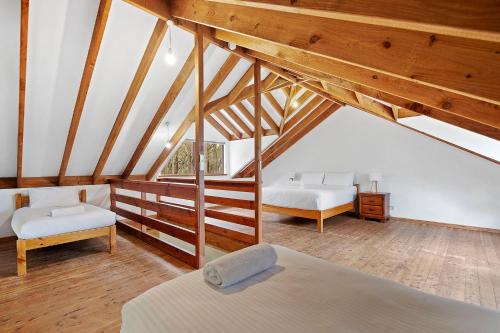 邓斯伯勒Kookaburra Cottage at Woodstone Estate的阁楼卧室设有两张床和木制天花板