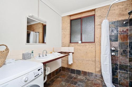 邓斯伯勒Kookaburra Cottage at Woodstone Estate的一间带水槽和淋浴的浴室