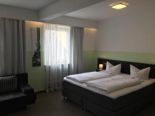 奥格斯堡法尔克奥格斯堡高德纳酒店的一间卧室设有一张大床和一个窗户。
