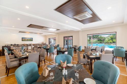 乌代浦Sarasiruham Resort - Private Pool Villa in Udaipur的一间配备有桌子和蓝色椅子的用餐室