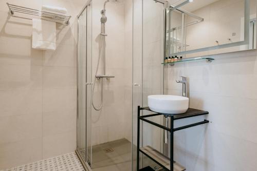 维多利亚Townhouse17 Boutique Bed & Breakfast的一间带玻璃淋浴和水槽的浴室