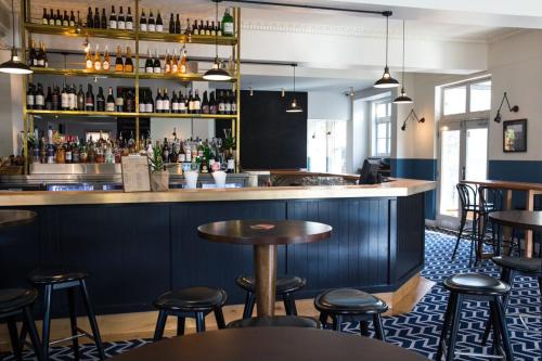 悉尼Blues Point Hotel的餐厅内带桌子和凳子的酒吧