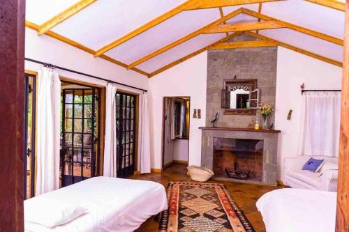 TimauChui Cottage with tennis facing Mt Kenya & near Ngare Ndare的一间卧室设有两张床和一个壁炉
