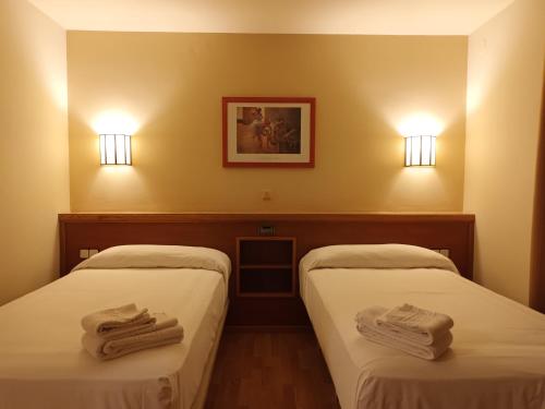 贝尔加爱斯特酒店的两张位于酒店客房的床,配有毛巾