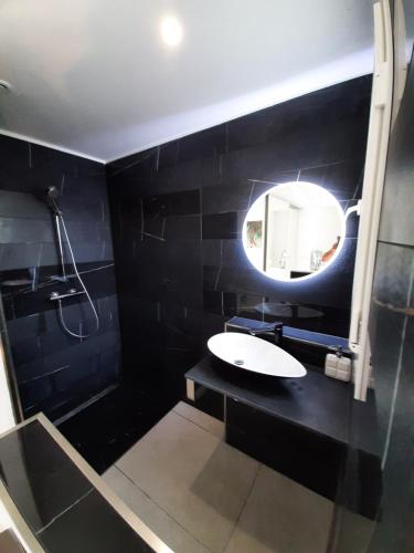 阿格德角VILLA RASOA chambre miroir的黑色浴室设有水槽和镜子
