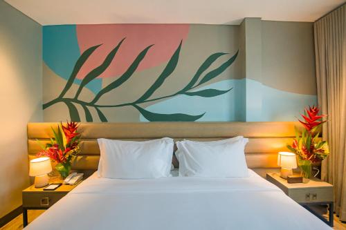 麦克坦1521 Hotel & Spa的卧室配有一张大床,墙上挂有绘画作品