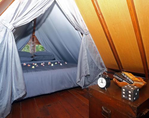 八丹拜The Hidden Escapes Manggis- Stunning Tiny Home set on a Lake with Mountain View, Private Sauna, Pool, Bicycles, BBQ & Butler!的帐篷内带床的房间