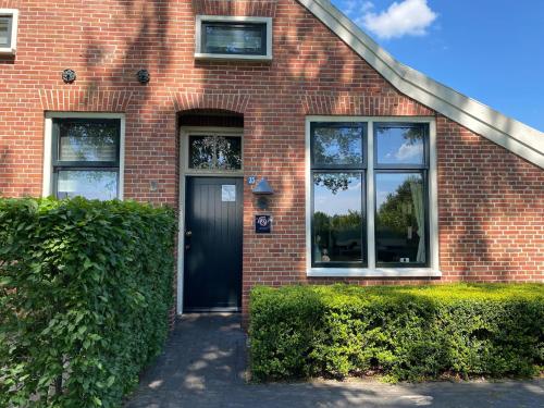 伊尔德帕特斯伍德Kindvriendelijk appartement de Hooge Stukken onder de rook van Groningen的红砖房子,有黑色的门