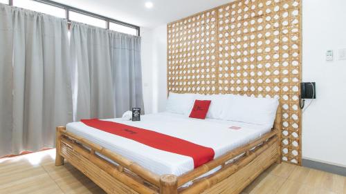 马尼拉RedDoorz at DBuilders Rooms Lower Bicutan的一间卧室配有一张带木制床头板的床
