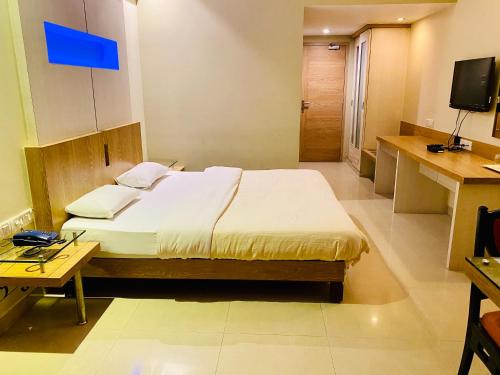 罗纳瓦拉Hotel Rama Krishna的一间卧室配有一张床和一台电视