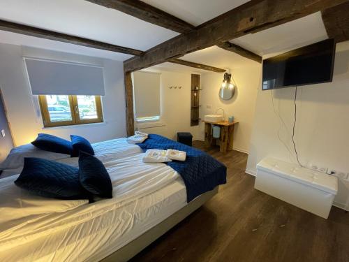 基尔维莱Bi d'Grosseltere Gîtes de charme的一间卧室配有一张带蓝色枕头的大床