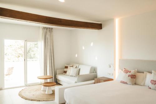 圣安东尼奥湾Hotel Boutique & Spa Las Mimosas Ibiza的白色卧室配有床和沙发