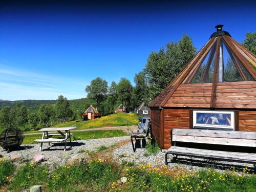 VårhusHessdalen Ufocamp的一个带野餐桌和野餐长凳的木屋