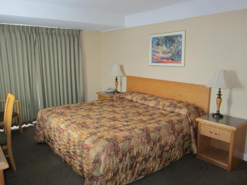 坎卢普斯星辰旅舍的酒店客房配有床、桌子和灯具