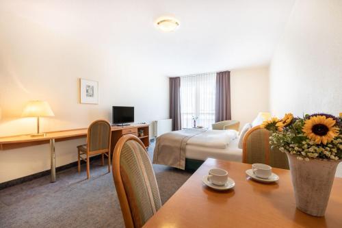 莱比锡acora Leipzig Living the City的酒店客房配有一张床铺和一张桌子。