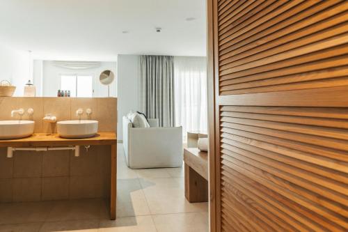 圣安东尼奥湾Hotel Boutique & Spa Las Mimosas Ibiza的一间带两个水槽和木门的浴室