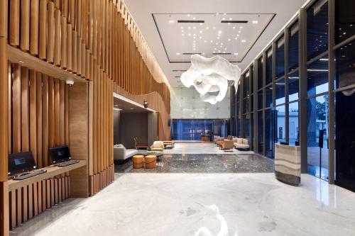三宝垄Hotel Aruss Semarang的设有一个铺有大型大理石地板并配有吊灯的办公大堂