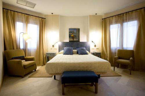 阿尔的伊索Hotel La Vida Spa的一间卧室配有一张大床和两把椅子