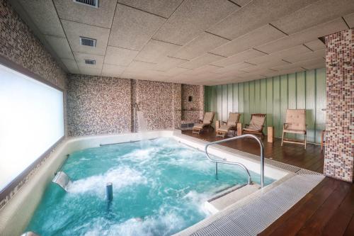 阿尔的伊索Hotel La Vida Spa的一个带桌椅的房间的按摩浴缸
