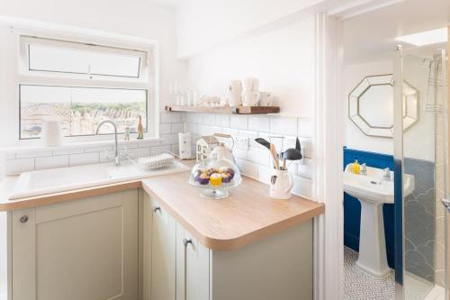 托基*Brand New* Olive Grove Cottage的厨房配有带水槽的柜台和窗户。