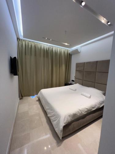 卡博尼格洛Lilac's GARDEN的卧室配有白色的床和窗户。