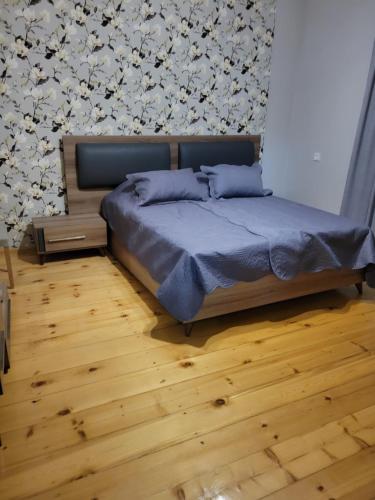 Vaniguest house TSVARA的一间卧室设有一张床和鲜花墙