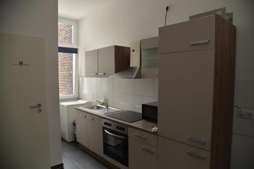 多特蒙德Design Apartments 1的厨房配有水槽和炉灶 顶部烤箱