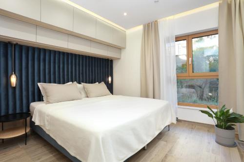 珀德垂那Apartments by the sea Podstrana, Split - 9714的卧室设有一张白色大床和一扇窗户。