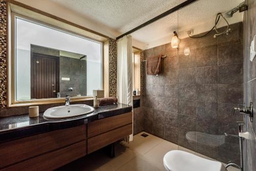 加尔利SaffronStays Boulevard LogHouse - a wooden chalet amidst nature的一间带水槽和镜子的浴室