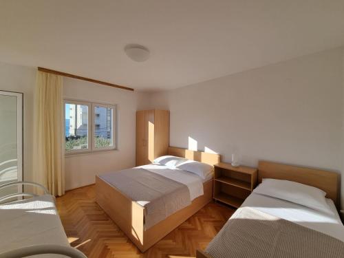 杜埃Apartments by the sea Duce, Omis - 2821的一间卧室设有两张床和窗户。