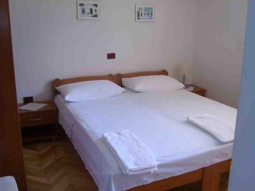 苏提万Double Room Sutivan 2943b的一张白色的床,上面有两个枕头