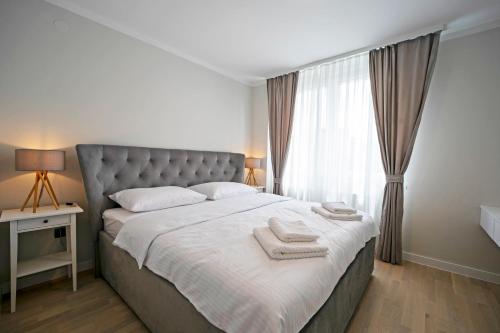 萨格勒布NEW!! High end 2bd modern apartment in Novi Zagreb的一间卧室配有一张大床和两条毛巾