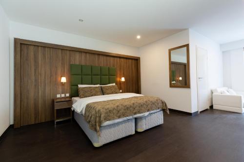 阿尔梅勒Hotel Cataleya的一间卧室配有一张大床和绿色床头板