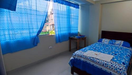 廷戈玛丽亚HOSPEDAJE EL CANTARO II的蓝色的卧室设有床和窗户