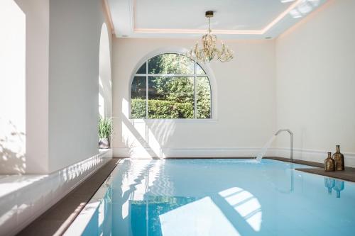 奥蒂塞伊阿姆斯塞特奈克经典酒店的白色客房的游泳池,设有窗户