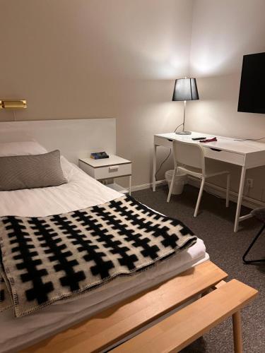 永比加瓦伦酒店的一间卧室配有一张床、一张桌子和一台电脑