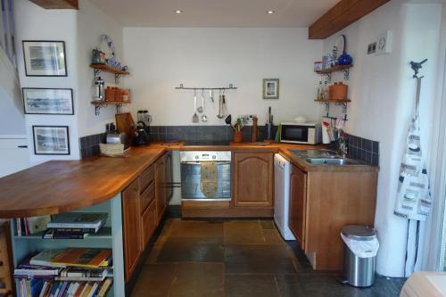 克雷迪顿St Michaels Coach House的厨房配有木制橱柜和台面