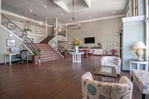 橙县最佳价格套房汽车旅馆的客厅设有楼梯、椅子和桌子