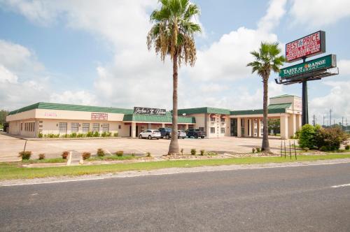 橙县最佳价格套房汽车旅馆的街道前有棕榈树的商店