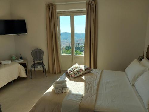 阿格里真托Masseria Torre Saracena的一间卧室设有一张床和一个大窗户