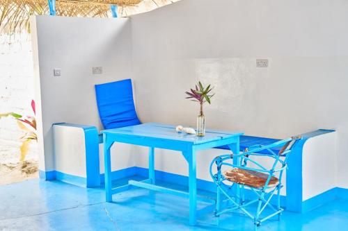 帕杰Beach House Paje的蓝色桌子和椅子,上面有花瓶