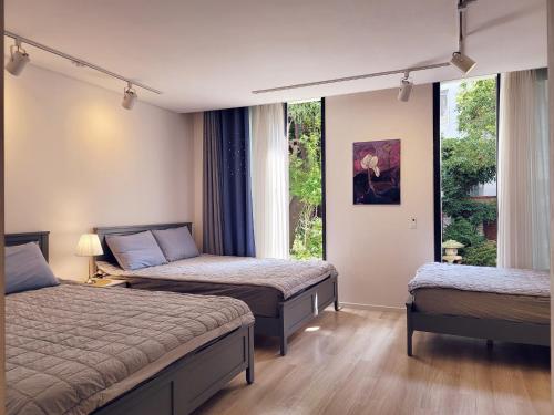 木浦市Gallery Family Hotel的一间卧室设有两张床和窗户。